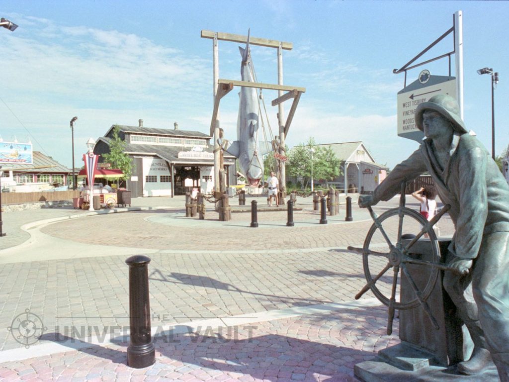 Amity Island at Universal Studios Florida in the early 1990s, with the JAWS shark hanging from the hoist and the Man at the Wheel statue in the foreground.